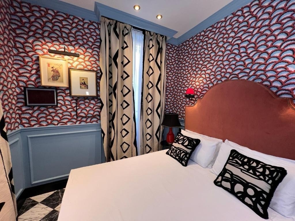 a bedroom with a bed a lamp and a picture on the wall