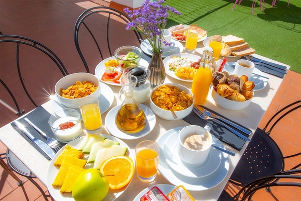 a table topped with plates of food and a bottle of orange juice