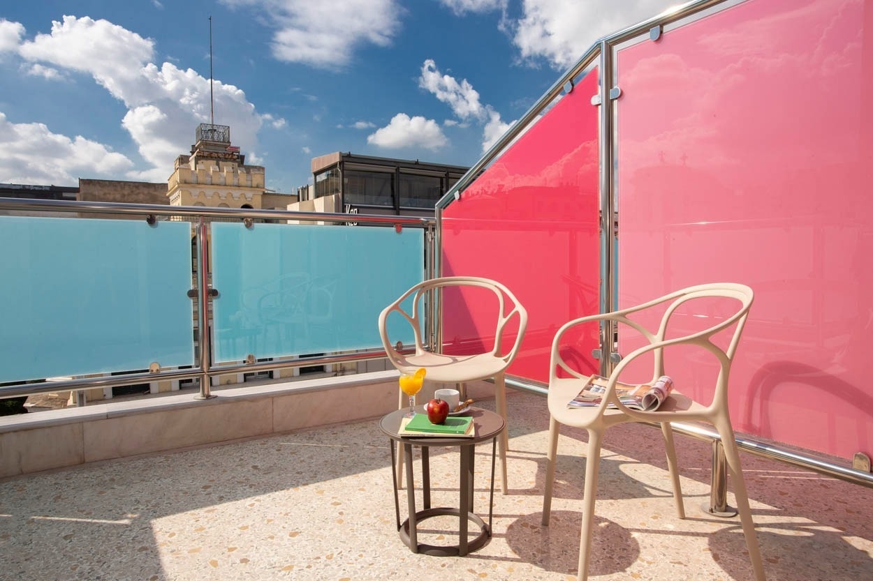 Gemütliche Dachterrasse im Casual Kubic Athens, mit Blick auf die Stadt und modernen Möbeln.