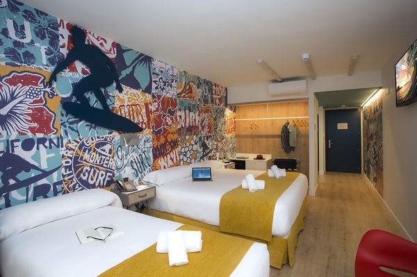 um quarto de hotel com duas camas e um laptop