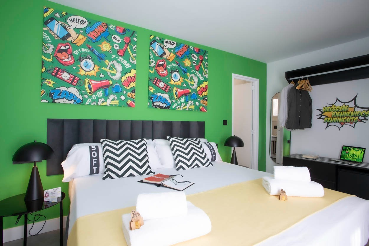 Pop-Art-Schlafzimmer im Casual Pop Art Benidorm, mit Comic-Wandkunst und auffälligen Kissen. Hotel in Benidorm.