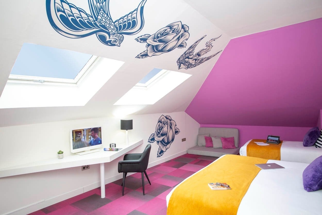 Habitación moderna Casual Ilbira Granada con decoración de tatuajes y camas cómodas.