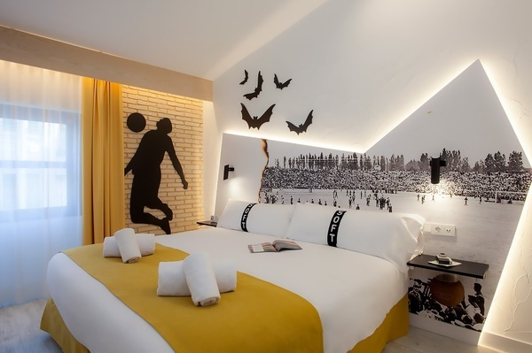 una habitación de hotel con una cama y una pared de ladrillo