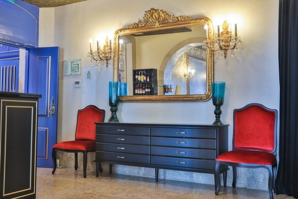 una habitación con dos sillas rojas y un espejo grande