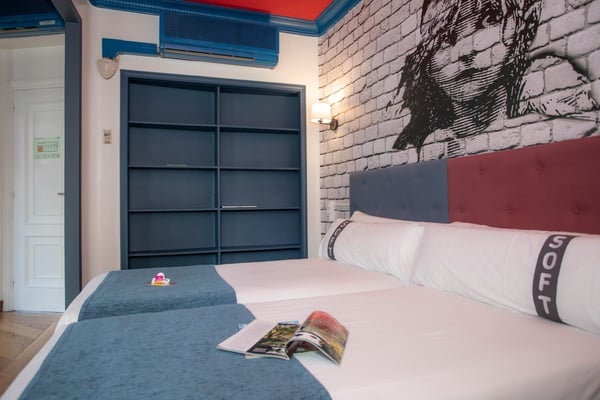 een hotelkamer met twee bedden en een kussen met de letters soft erop