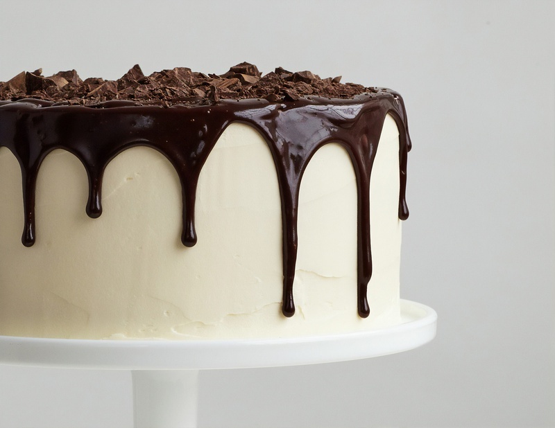 een taart met witte frosting en chocoladeglazuur