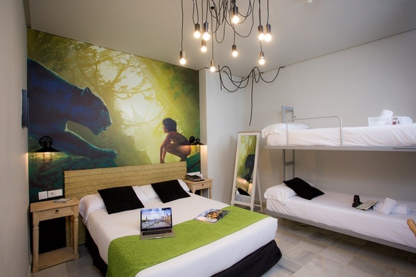 a room with a bed and bunk beds and a laptop on the bed