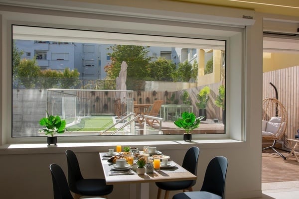 a table and chairs in front of a window with a view of a pool