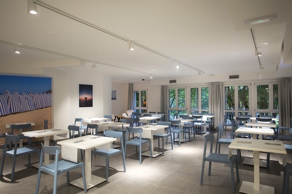 uma sala de jantar com muitas mesas e cadeiras