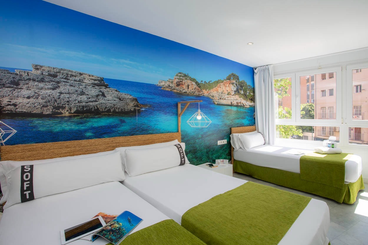 Gemütliches Zimmer im Casual del Mar Málaga: Doppelbett & Einzelbett mit Meeresblick-Wandbild & grünen Akzenten.