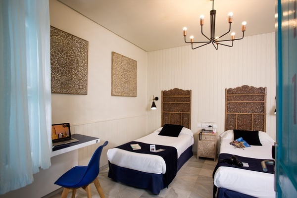 a bedroom with two twin beds and a desk with a laptop on it