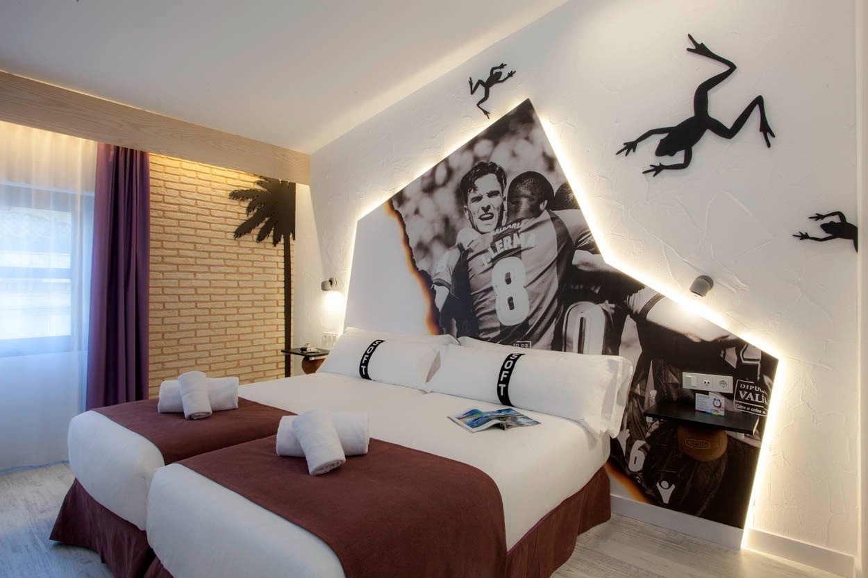 Habitación temática en Casual Socarrat Valencia con cama doble y mural deportivo.