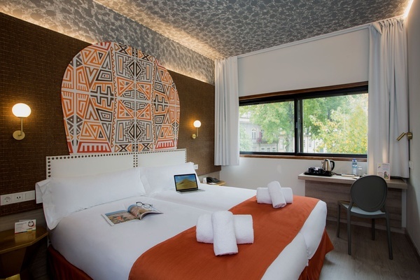 a hotel room with two beds and a laptop on the bed