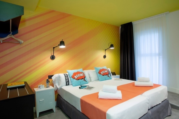 una habitación colorida con una cama y almohadas que dicen boom