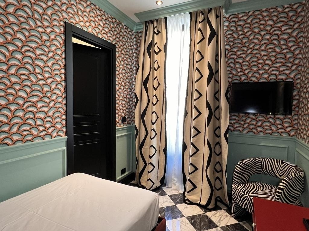 a bedroom with a bed a chair and a television