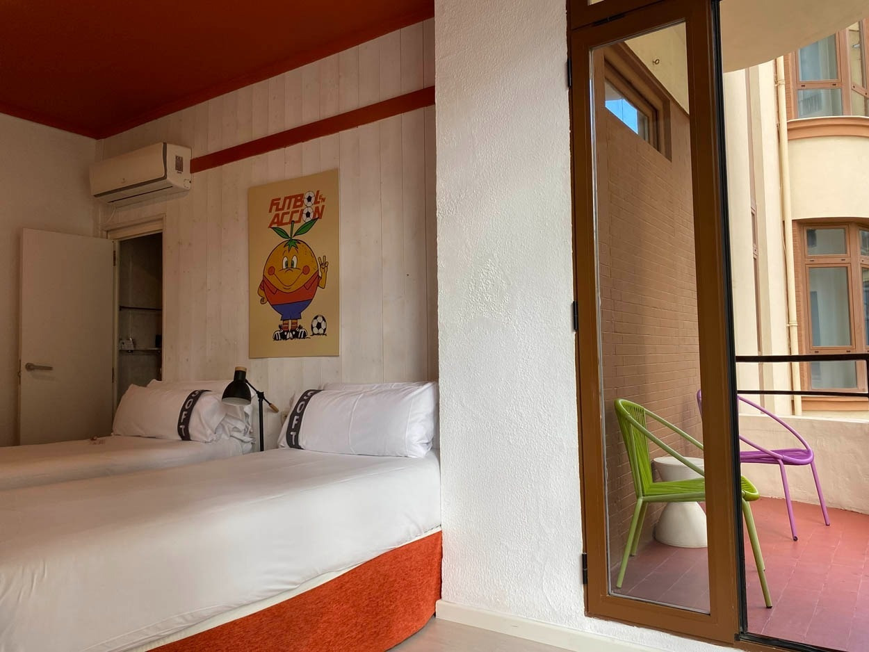Habitación doble cómoda con camas gemelas, decorada con un cartel vintage. ¡Casual Vintage Valencia - Hotel céntrico!