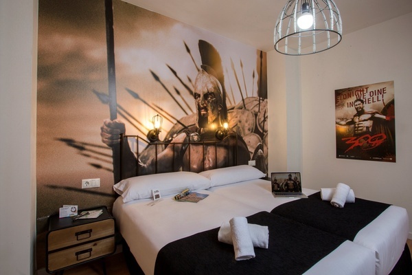 una habitación con una cama y un cartel de la película 300