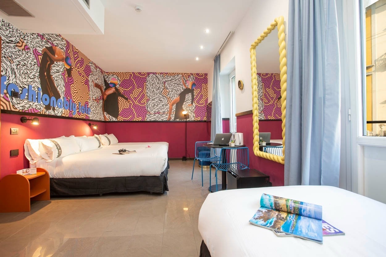 Modernes Zimmer im Casual Eclettico Milano mit bunter Wandkunst und Doppelbett, nahe Bahnhof Centrale.