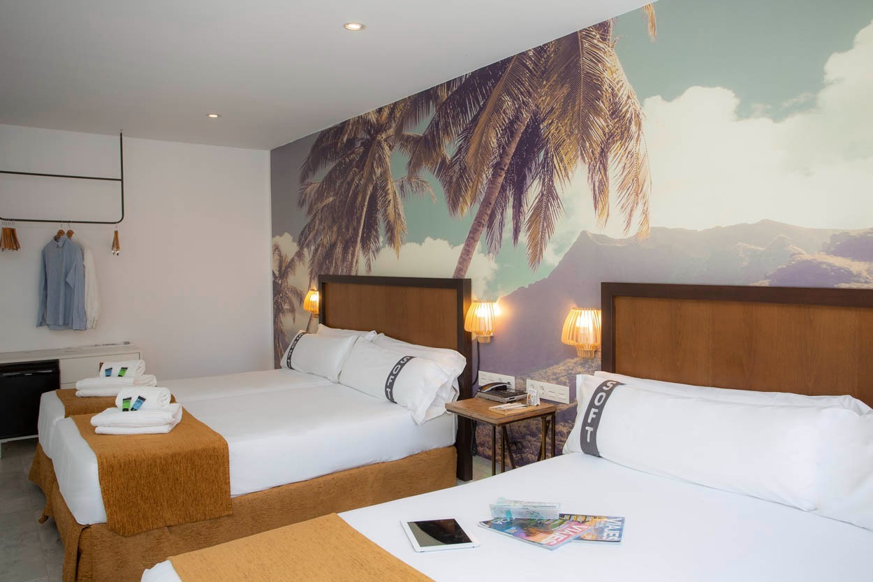 Geräumiges Hotelzimmer mit zwei Doppelbetten und tropischem Wandbild im Casual del Mar Málaga, Zentrales Hotel in Meeresnähe in Málaga | Casual Hoteles.