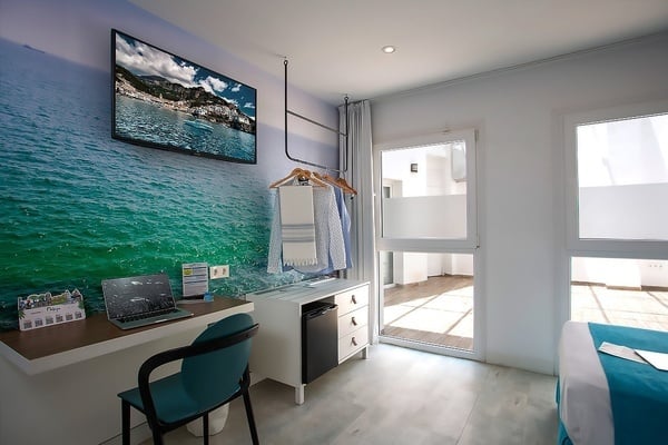 una habitación de hotel con un escritorio y una computadora portátil