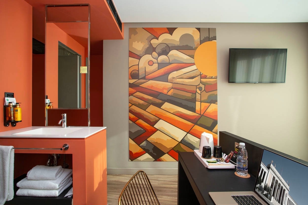 Modernes Hotelzimmer mit Kunstwerk und Laptop im Casual Kubic Athens Hotel