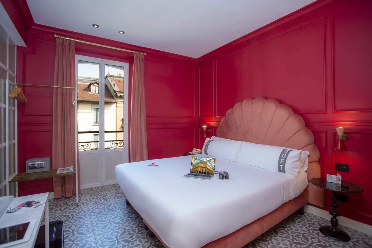 Ein luxuriöses Zimmer im Casual Eclettico Milano - Hotel Mailand, mit opulentem Himmelbett & roter Wandgestaltung.
