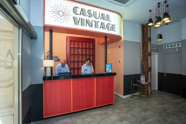 two men behind a counter that says casual vintage