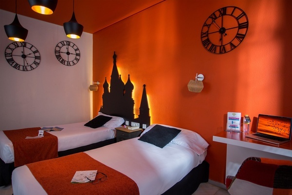 a room with two beds and a clock that says xii on it