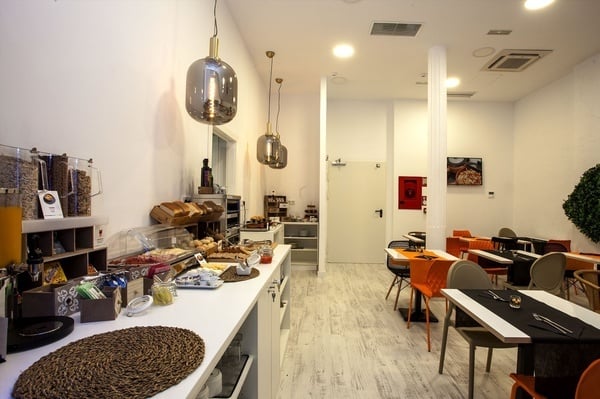 una habitación llena de mesas y sillas con un cartel en la pared que dice ' cocina '