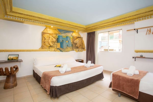 una habitación con dos camas y una pintura de leones en la pared