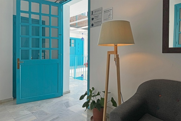una puerta azul y una lámpara en un pasillo