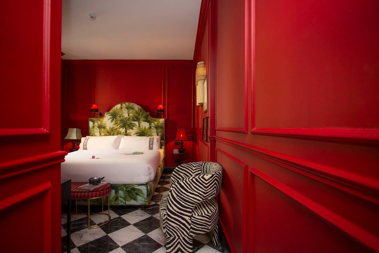 Luxuriöses Zimmer im Casual Eclettico Milano - Hotel Mailand nähe Bahnhof Centrale mit auffälligem Palmenkopfteil und Zebra-Sessel.