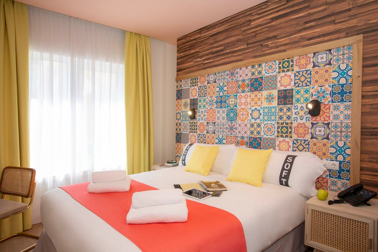 Stanza colorata con letto matrimoniale e testiera piastrellata, Casual Raízes Porto - Boutique hotel.