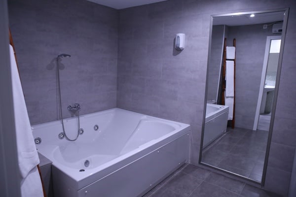 un baño con una bañera y un espejo