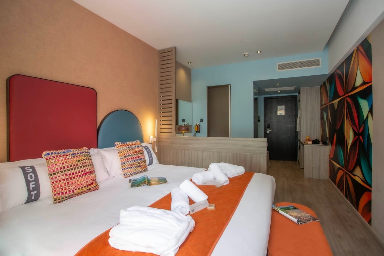 Modernes Hotelzimmer im Casual Kubic Athens, mit bunten Akzenten und bequemen Betten.