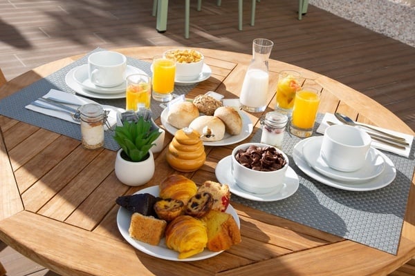 a wooden table topped with plates of food and drinks