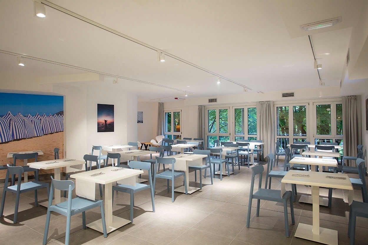 Helles Speisezimmer im Casual de las Olas San Sebastián mit Tischen & Stühlen.