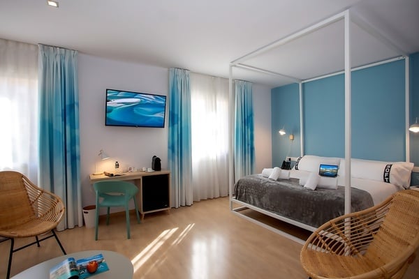 une chambre d' hôtel avec un lit à baldaquin et une télévision