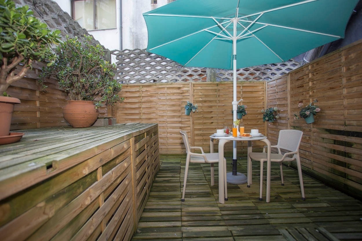 Gemütlicher Terrassenbereich des Casual Inca Porto Hotels mit Tisch und Stühlen.