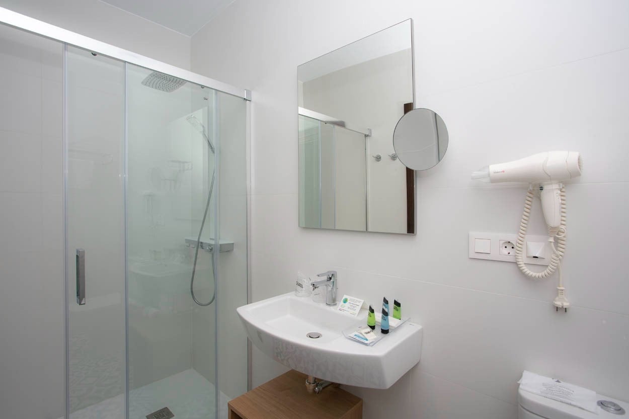 Modernes Badezimmer mit Dusche, Waschbecken und Haartrockner im Casual con Duende Cádiz - Hotel im historischen Zentrum von Cádiz | Casual Hoteles.