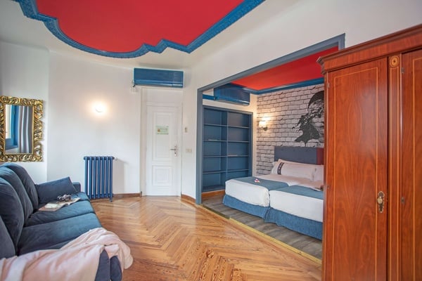 een slaapkamer met twee bedden en een blauwe radiator