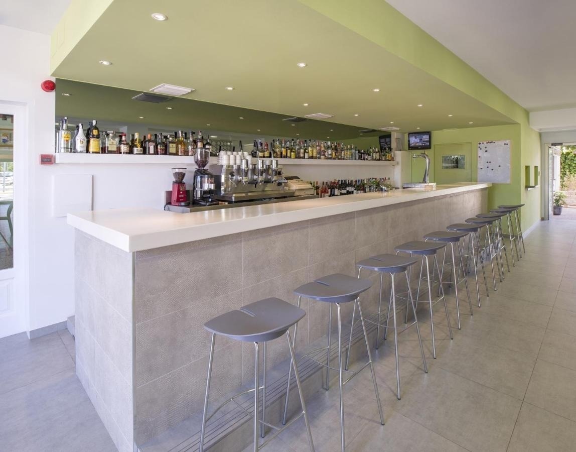 a long bar with stools and a coffee maker