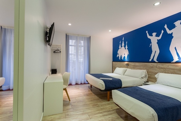 a hotel room with two beds and a blue wall