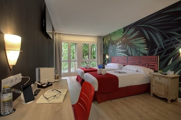 um quarto de hotel com duas camas e uma mesa