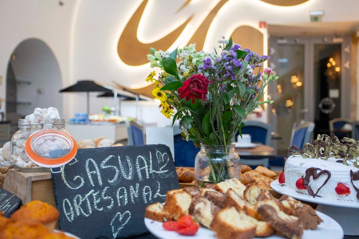 Buffet mit Kuchen und Blumen im Casual Belle Époque - Boutique-Hotel im Zentrum von Lissabon.