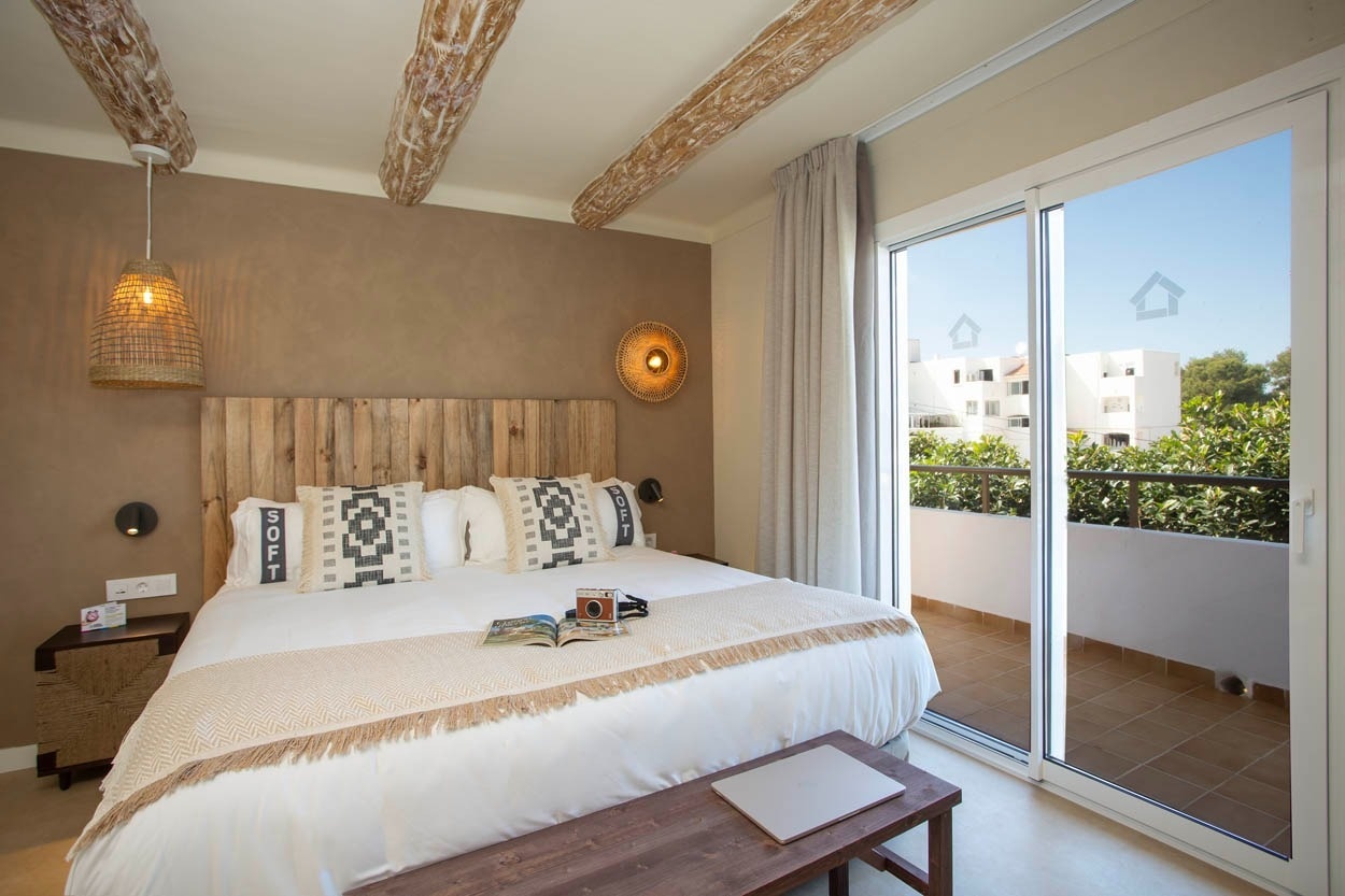 Chambre spacieuse avec lit king-size, balustrade et vue sur la mer à Casual Bahía Ibiza, hôtel près de la plage.