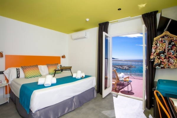una habitación con una cama y una puerta que da a un balcón