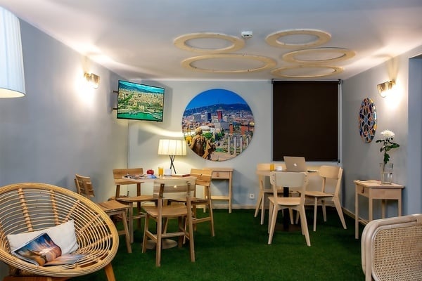 une salle avec des tables et des chaises et une peinture ovale sur le mur