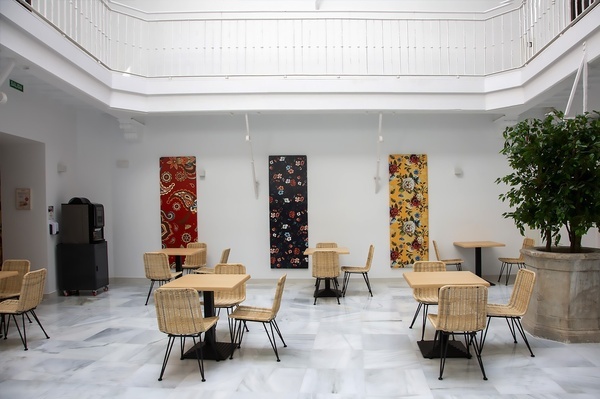 a room with tables and chairs and paintings on the wall