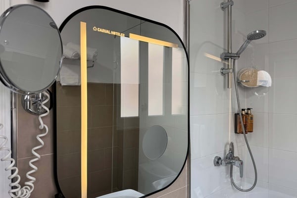 een badkamer met een ovale spiegel en een douche